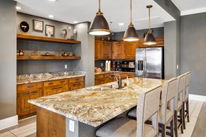 Flower Mound apartment for rent - a kitchen with granite counter tops and a long island with chairs
