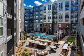 Atlanta apartment for rent - an open courtyard with a pool and tables in front of an apartment building
