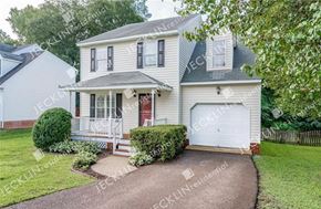 Henrico house for rent - A two-story house with a white garage door and a brick driveway.
