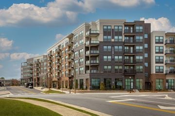 Chamblee apartment for rent - A row of modern apartment buildings line a tree-lined street.