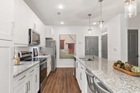 Duluth apartment for rent - A kitchen with white cabinets and a granite countertop.