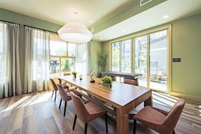 Duluth apartment for rent - a dining room with a long wooden table and chairs