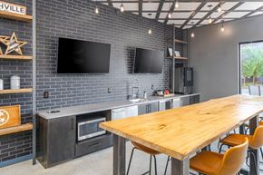 Nashville apartment for rent - a kitchen with a wooden table and two televisions