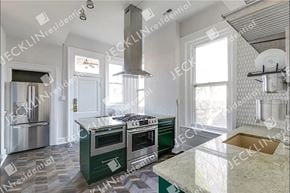 Richmond house for rent - A kitchen with a green island and stainless steel appliances.