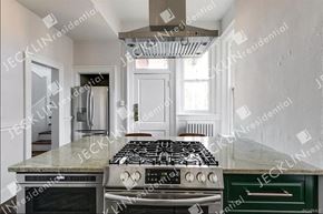 Richmond house for rent - A modern kitchen with a green drawer and a black and white stove top.
