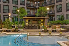 Chamblee apartment for rent - A large swimming pool in front of a building with a patio area.