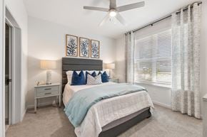 Duluth apartment for rent - A bedroom with a bed, nightstand, and a ceiling fan.