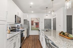 Duluth apartment for rent - A kitchen with white cabinets and a marble countertop.