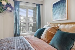 Atlanta apartment for rent - A bedroom with a large bed and a window with curtains.