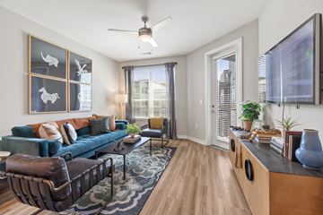 Atlanta apartment for rent - A living room with a blue couch and a television on the wall.