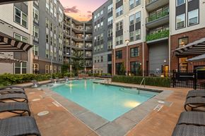 Atlanta apartment for rent - A swimming pool surrounded by lounge chairs in front of apartment buildings.
