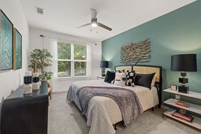 Atlanta apartment for rent - A bedroom with a bed, a ceiling fan, and a window.