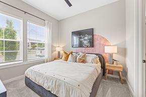 Cumming apartment for rent - A bedroom with a large bed and a ceiling fan.