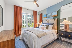 Chamblee apartment for rent - A bedroom with a large bed and a wooden headboard.