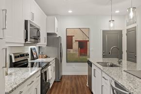 Duluth apartment for rent - A kitchen with white cabinets and a painting hanging on the wall.