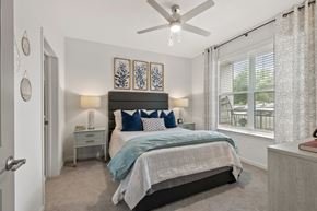 Duluth apartment for rent - A bedroom with a bed, nightstand, and a ceiling fan.