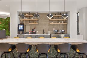Chamblee apartment for rent - A modern kitchen with a long table and chairs.