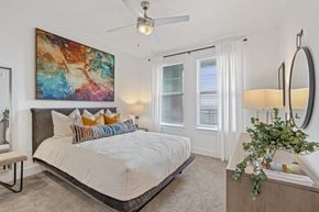 Duluth apartment for rent - A bedroom with a large bed and a painting on the wall.