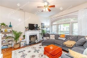 Richmond house for rent - A living room with a grey couch, a fireplace, and a ceiling fan.