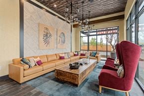 Nashville apartment for rent - A living room with a tan couch and a red chair.
