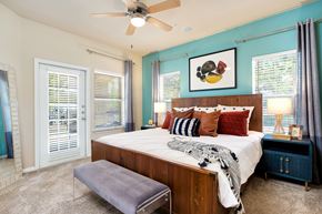 Cedar Park apartment for rent - a bedroom with a large bed and a ceiling fan