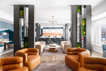 Nashville apartment for rent - A modern living room with orange leather chairs and a glass table.