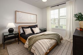 Columbia apartment for rent - a bedroom with a bed and a window with white curtains