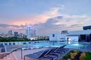 Fort Worth apartment for rent - A rooftop pool area with lounge chairs and a city skyline in the background.