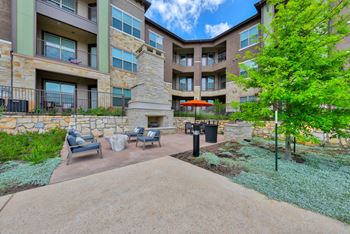 Poolside stone fireplace with cozy seating and grilling area