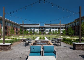 Outdoor lounge with covered grills, pizza oven, and seating area