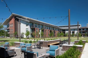 Outdoor lounge with covered grills, pizza oven, and seating area