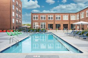 Nashville apartment for rent - a swimming pool with lounge chairs in front of a building