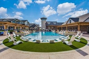 Mckinney apartment for rent - a swimming pool with white chairs in front of a house