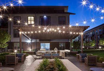 Outdoor lounge with covered grills, pizza oven, and seating area
