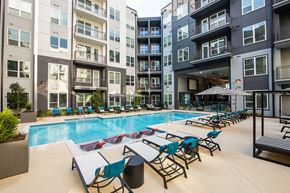 Atlanta apartment for rent - an outdoor pool with lounge chairs and tables at an apartment building