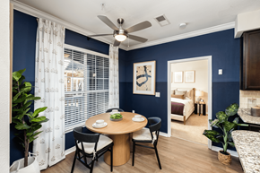 Charlotte townhouse for rent - A dining room with a table set for two and a view of a bedroom through the window.