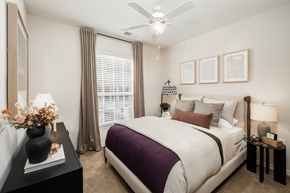 Charlotte townhouse for rent - A bedroom with a large bed and a ceiling fan.