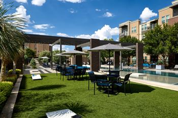 Poolside game area with cornhole boards