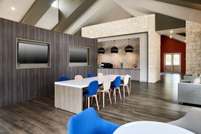 Mckinney apartment for rent - A modern dining room with a white table and blue chairs.