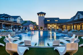 Mckinney apartment for rent - A large white pool surrounded by chairs in front of a house.