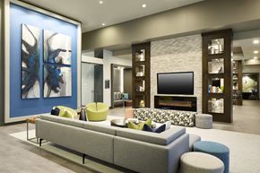 Fort Worth apartment for rent - A living room with a grey couch and a large painting on the wall.
