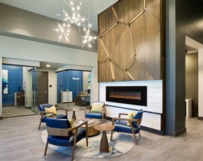 Fort Worth apartment for rent - A modern living room with a fireplace and blue chairs.