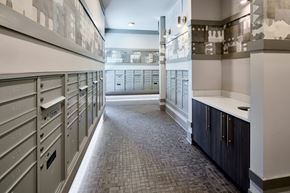 Fort Worth apartment for rent - A long hallway with a row of mailboxes on the left and a row of cabinets on the right.