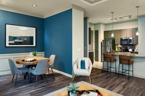 Mckinney apartment for rent - A modern kitchen with blue walls and a dining table set for four.