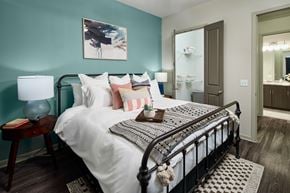 Mckinney apartment for rent - A bedroom with a large bed and a painting on the wall.