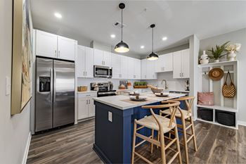 White shaker-style cabinetry with blue kitchen island with gold fixtures