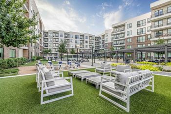 North building courtyard with grilling and picnic area, swings, fire pit with cozy seating, and yard game area