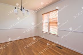 Henrico house for rent - A room with wooden floors and a window with blinds.