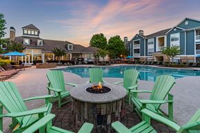 Cary apartment for rent - A fire pit surrounded by green chairs sits in the middle of a pool area.