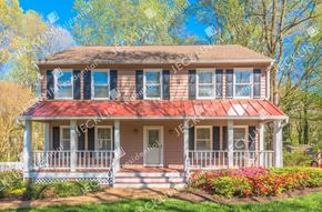 Henrico house for rent - A house with a red roof and a white porch.
